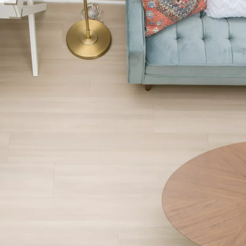 Light vinyl flooring in a small living space with a white desk chair and blue sofa