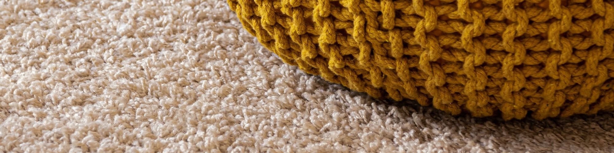 Carpet closeup with yellow ottoman